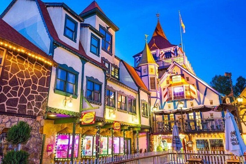 A brightly lit building with a tower, a signboard, and a fence. 5