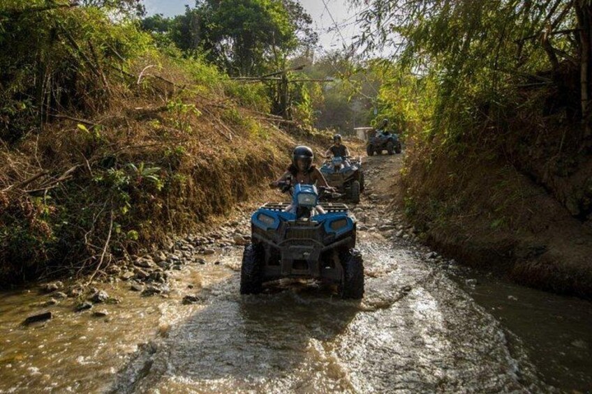 A narrow water crossing with off-road vehicles navigating through a stream. 4