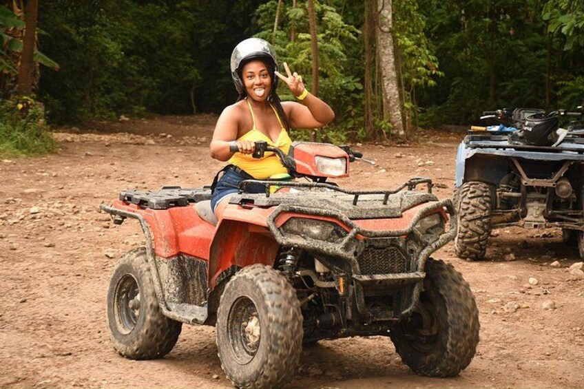 A person on a red ATV in a forested area. 3