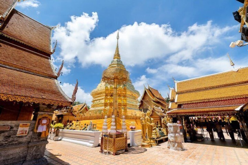A golden stupa surrounded by traditional Thai architecture. 1