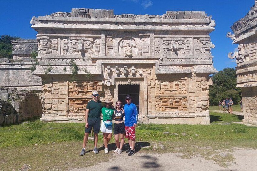 A stone structure with intricate carvings, a clear sky, and a grassy area. 5