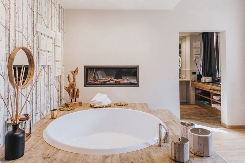 Een moderne badkamer met een groot bad, houten decoratie aan de muur en een lijst met een foto. 5
