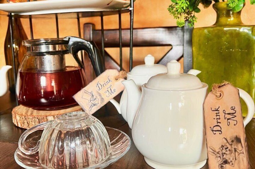 Een theeservies met een theepot, een suikerpot en een glazen karaf op een houten tafel. 4