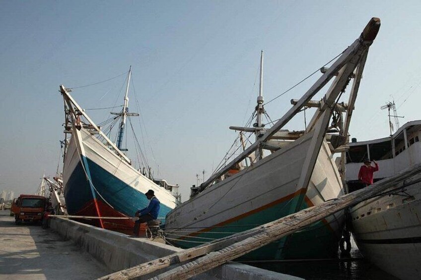 Un barco amarrado y una persona de pie en el muelle. 2