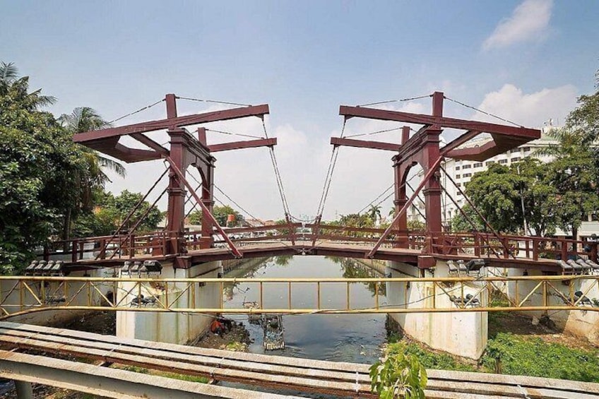 Un puente metálico rojo sobre una masa de agua con una estructura de concreto debajo. 4