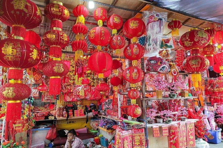 Un puesto de mercado con faroles rojos y diversos artículos a la venta. 2