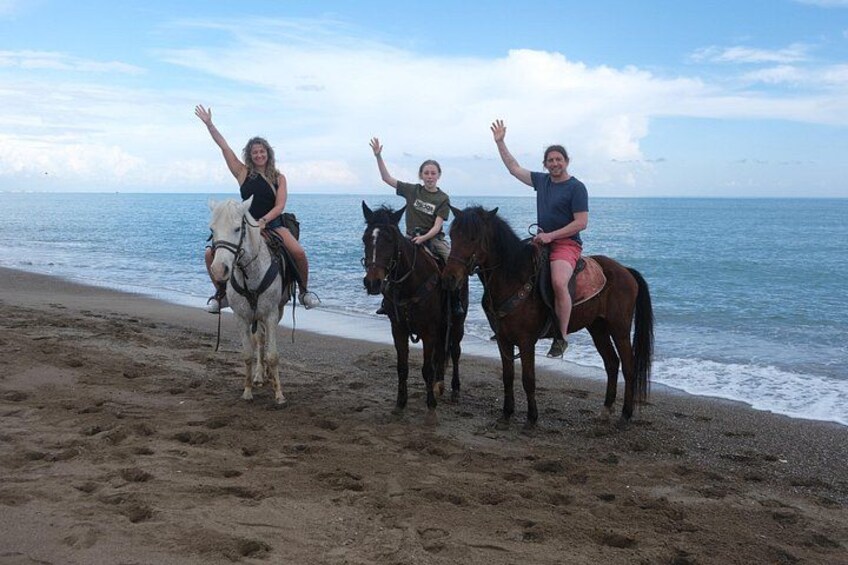 Trois personnes à cheval sur une plage, avec l’océan en arrière-plan. 4