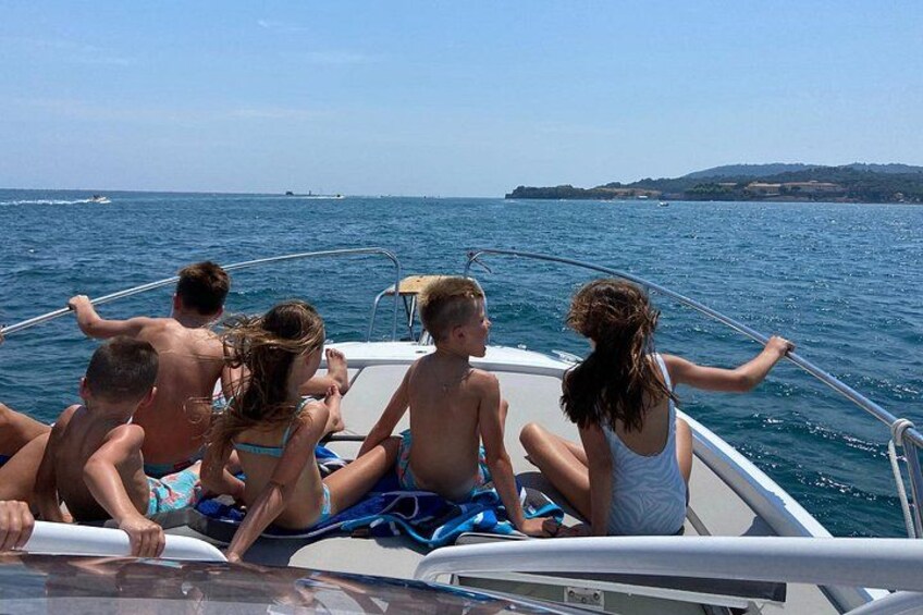 Un groupe de personnes se trouve sur un bateau en pleine mer, avec une côte visible au loin. 3