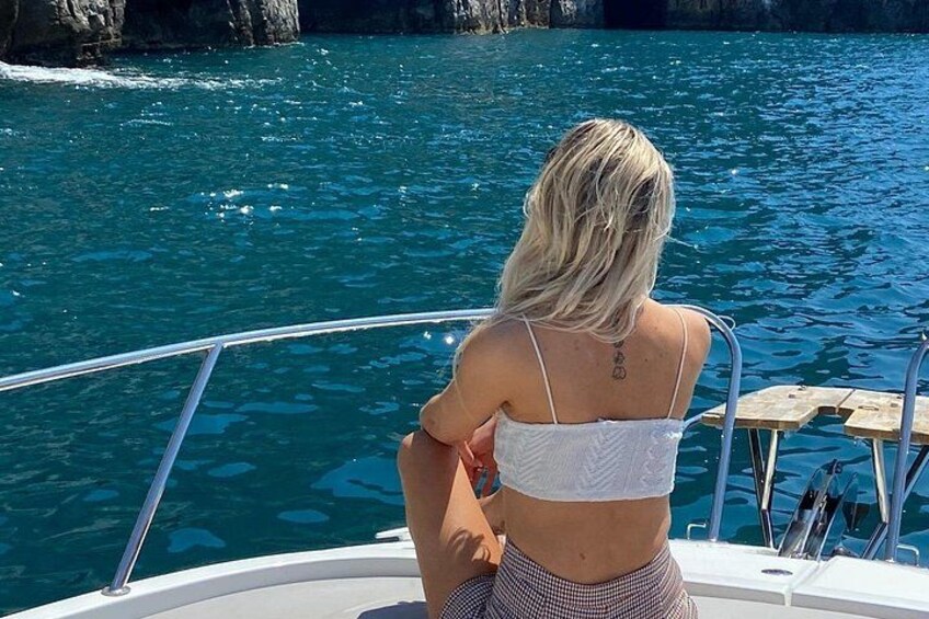 Une personne à bord d’un bateau, avec un tatouage sur le dos, qui regarde l’eau. 4