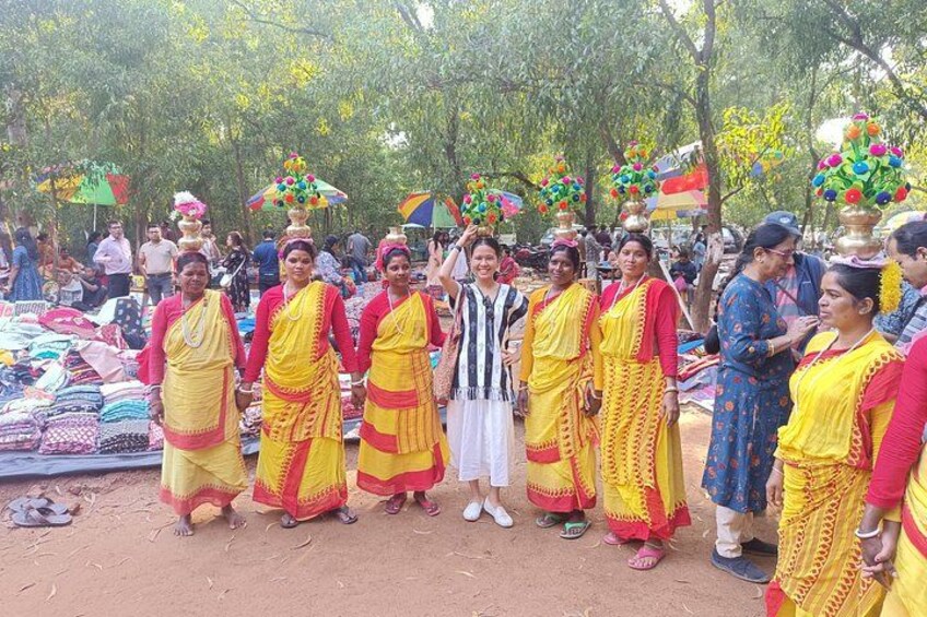 A group of women in traditional yellow and red attire standing at a market stall. 4
