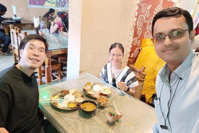 A dining table with various dishes and a person holding a chopstick. 3