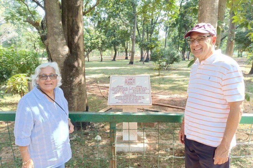 Two people standing in a park with a signboard between them. 3
