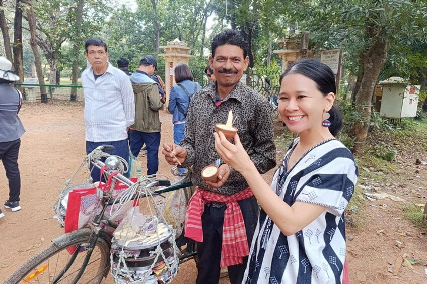 A person holding a small object, a bicycle with a basket, and a person in a patterned shirt. 4