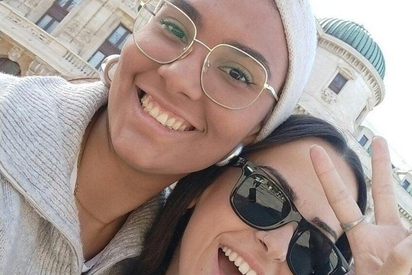 Two people taking a selfie with a historic building in the background. 3