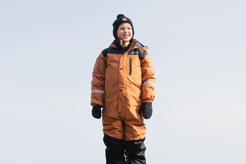 A person wearing a long orange coat and black gloves. 2