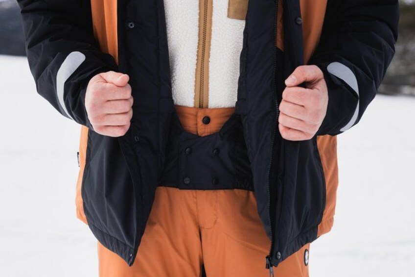 A person wearing a black jacket, white shirt, and orange pants. 3