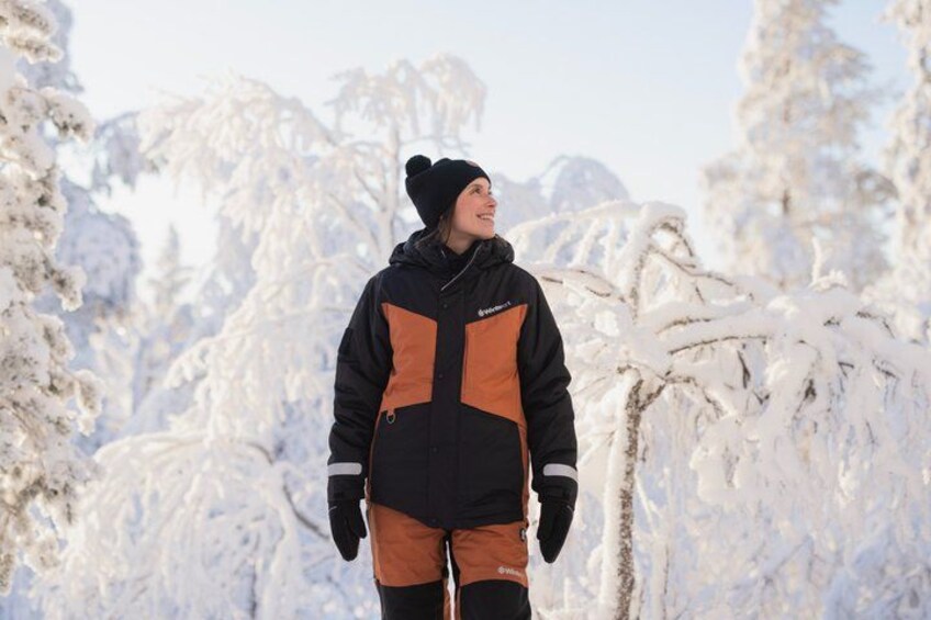 A person standing in a snowy forest with trees covered in snow. 4