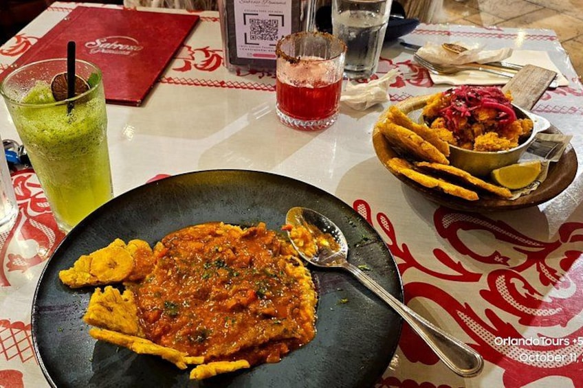 Una mesa con un plato de comida, una bebida y un menú. 3