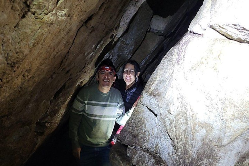 Two people inside a cave with rocky walls. 3