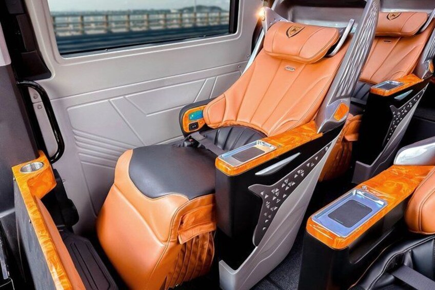 A luxury vehicle interior with leather seats, wooden trim, and a sunroof. 3