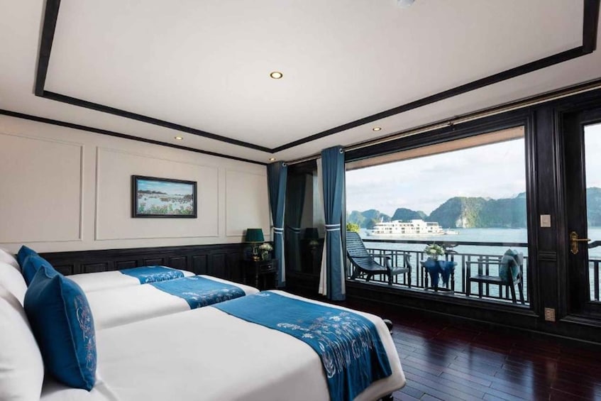 Una camera d'albergo con un'ampia finestra vista su un lago e montagne. 1