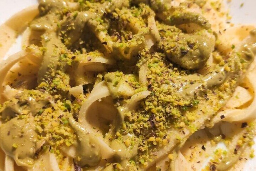 Un piatto di pasta con salsa cremosa e guarnizione verde. 1