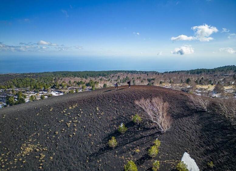 A volcanic landscape with a person hiking. 4