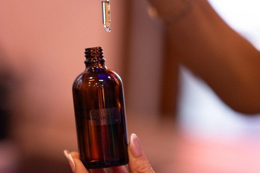 A hand holding a brown bottle with a dropper, labeled 'Chocolate.' 3
