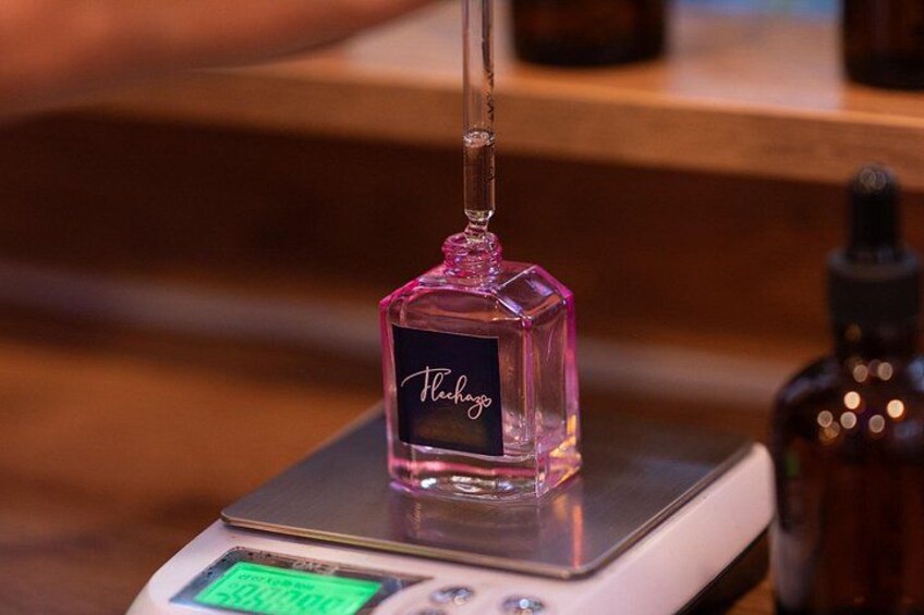 A perfume bottle on a digital scale with a display showing 0.0000. 2