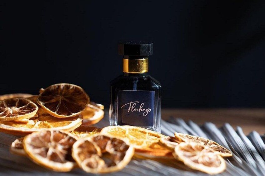 A bottle of perfume with dried orange slices and cinnamon sticks. 5