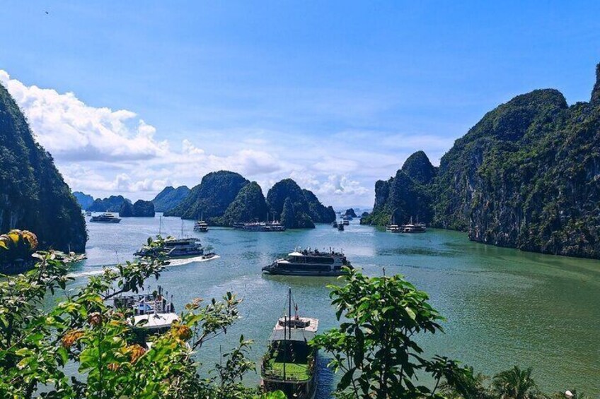 A coastal scene with boats, greenery, and limestone cliffs. 3