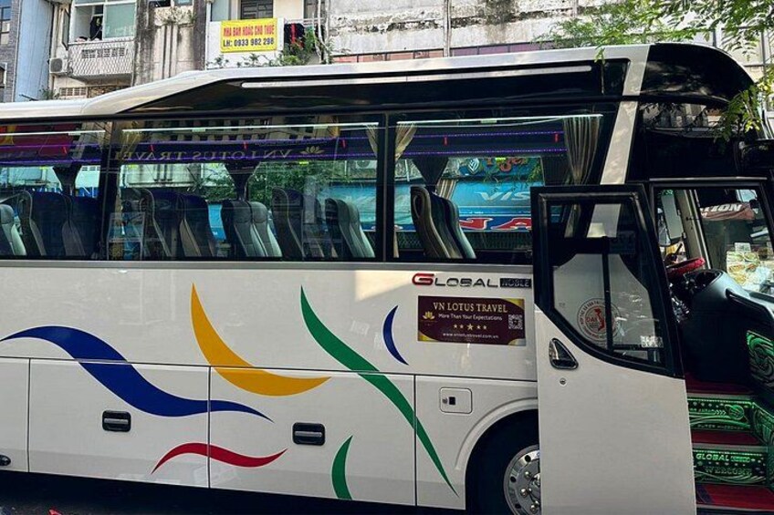 Un autobús blanco con diseños coloridos y un cartel que dice 'GLOBAL HOUSE'. 3