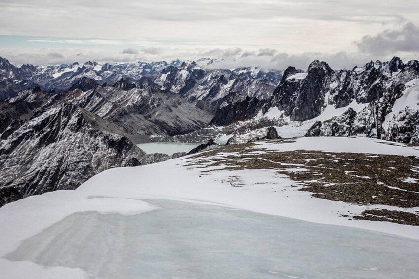 A snow-covered mountain range with a glacier and a lake. 5