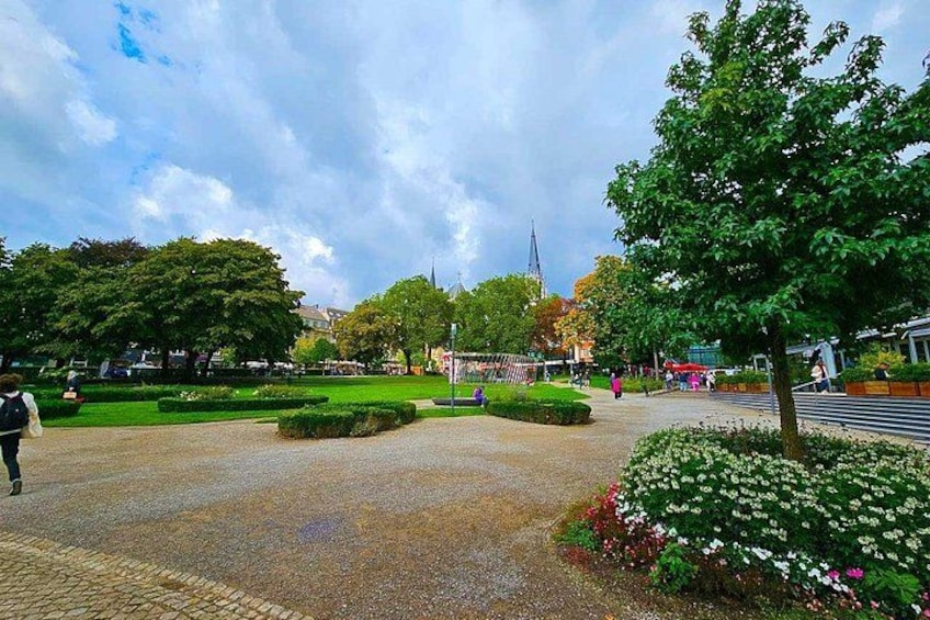 A park with pathways, trees, and flowers. 2