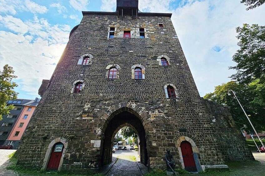 A historic stone tower with arched windows and a red door. 5
