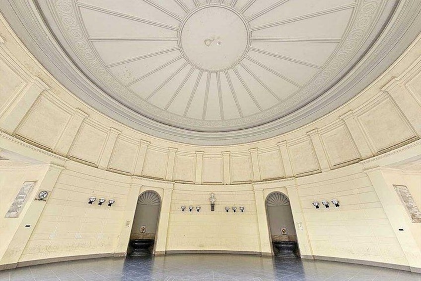 A grand hall with a domed ceiling, arched doorways, and a central staircase. 3