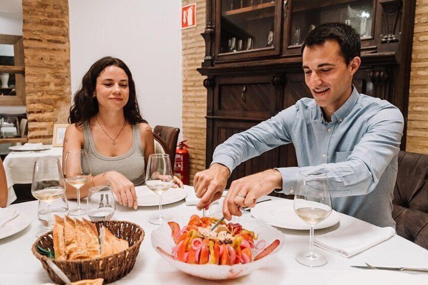 Une table à manger avec du pain, une salade et des verres à vin. 5