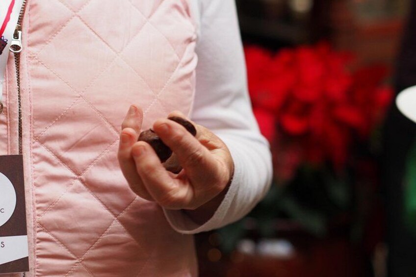 Una persona indossa un gilet trapuntato rosa e tiene in mano un piccolo oggetto. 3