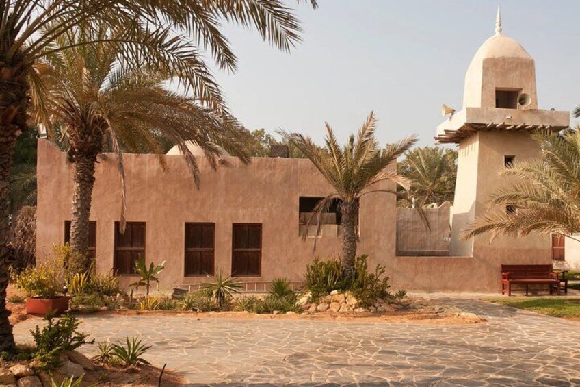 Un edificio tradizionale con una cupola e un cortile circondato da palme. 4