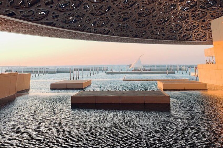 Una vasca d'acqua interna con zone relax e vista su un ponte sullo sfondo. 2