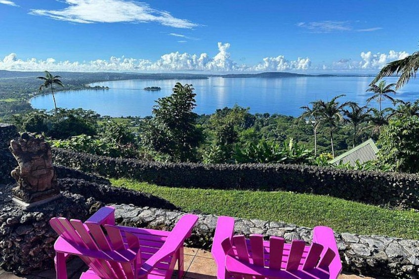 Un paysage côtier magnifique, avec un ciel bleu dégagé, une mer calme et une végétation luxuriante. 5