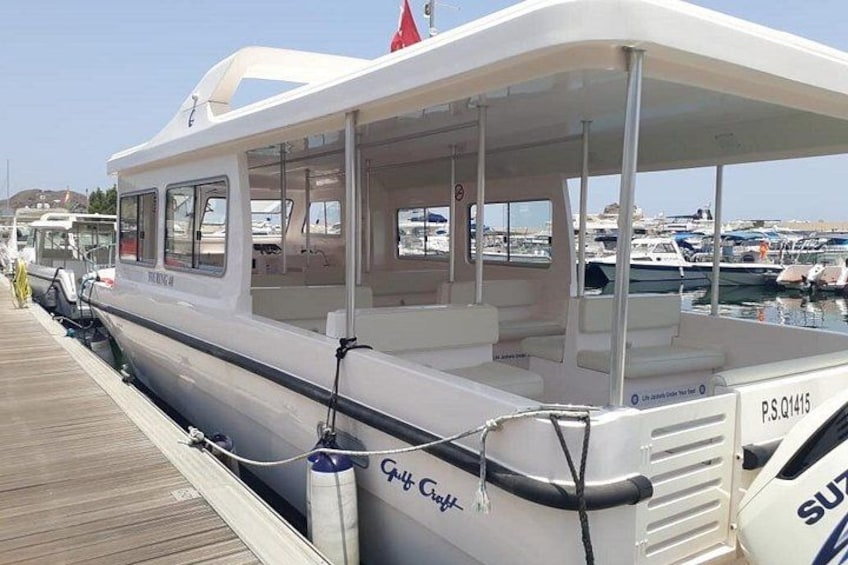 Un barco blanco amarrado en un puerto deportivo bajo un cielo despejado. 5