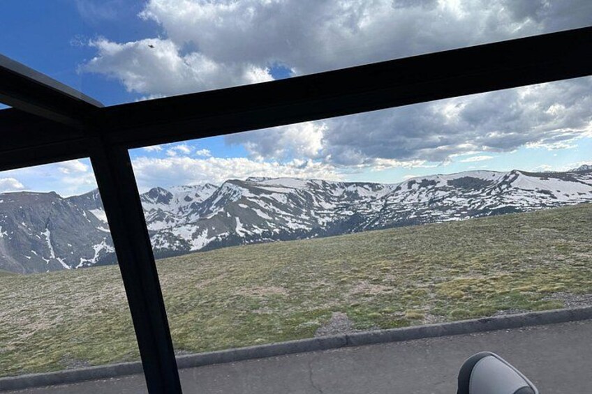 A mountainous landscape with snow-capped peaks, a clear sky, and a road in the foreground. 5
