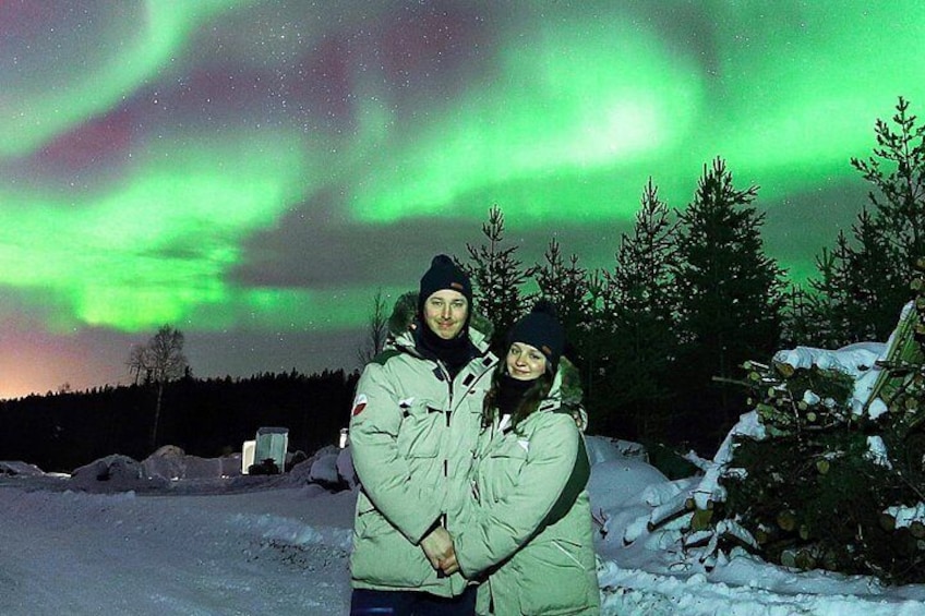 Dos personas en un paisaje nevado, con vistas a las auroras boreales. 2