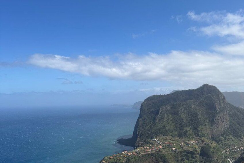 Un paysage côtier caractérisé par une falaise imposante et un petit village situé à son pied. 3