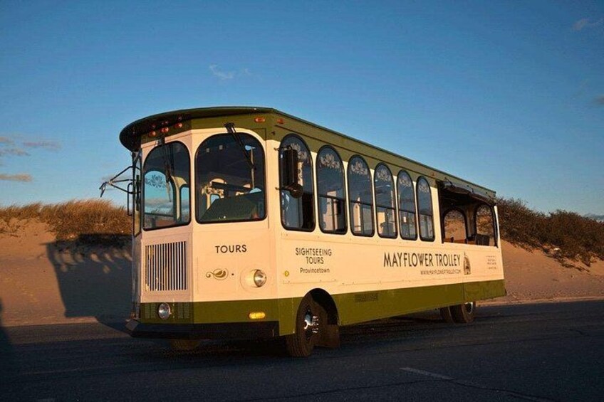 Un autobús antiguo con la leyenda 'TOURS' y 'MAYFLOWER TROULEY' escrito, estacionado en una carretera con un cielo despejado al fondo. 5