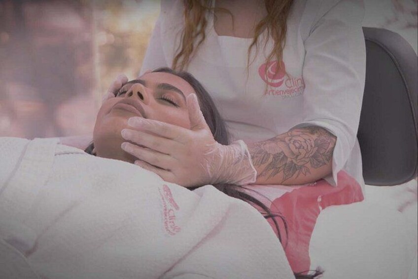 Una persona acostada con una manta blanca, un brazo tatuado y un logotipo en la pared. 5