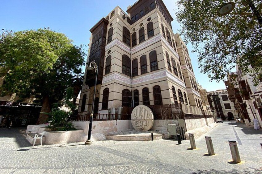 A historic building with arched windows and a large circular emblem. 4