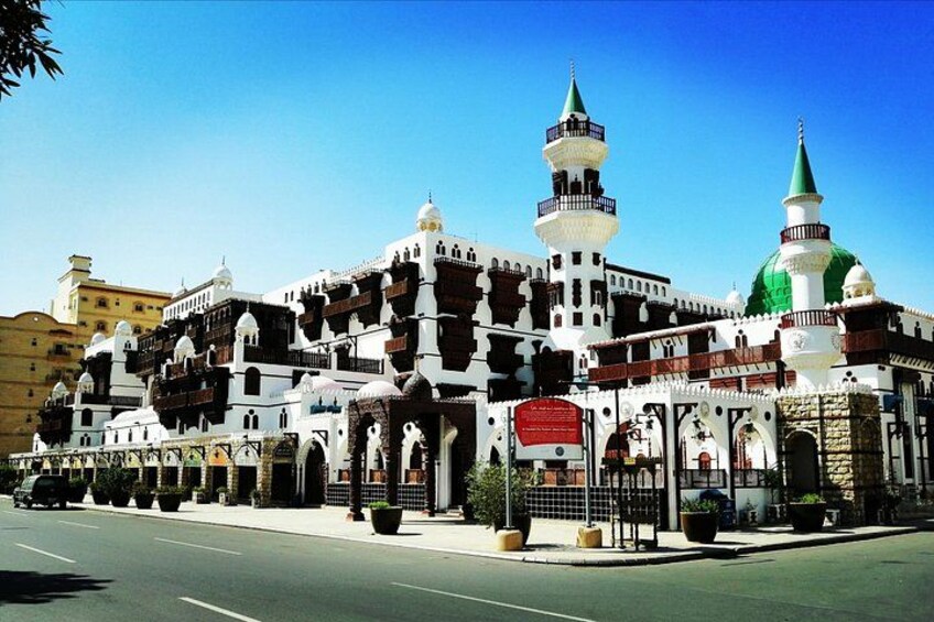 A large, ornate building with multiple domes and towers, surrounded by a paved area and a clear sky. 3