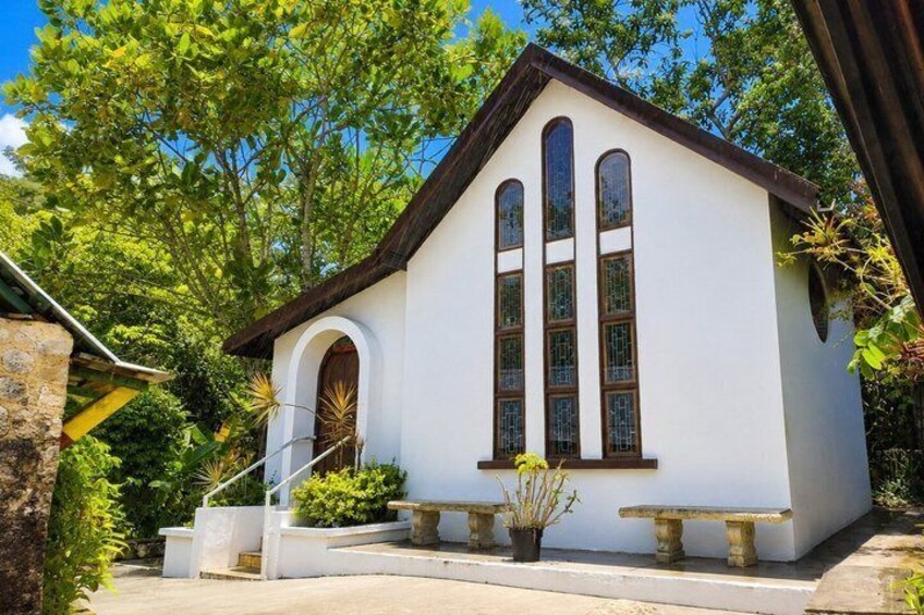 A white building with a brown roof, arched entrance, and large windows. 2